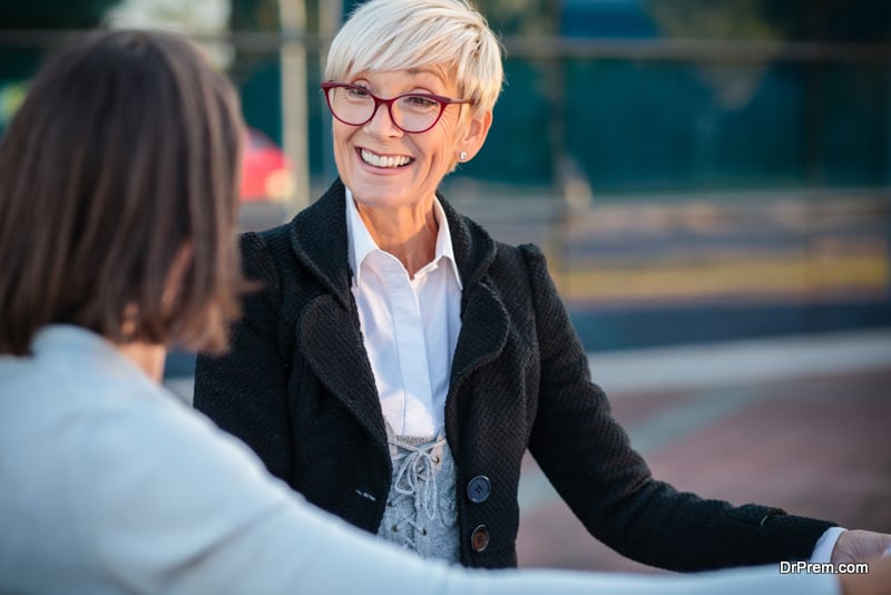 Happy senior Caucasian woman talking with young female stranger