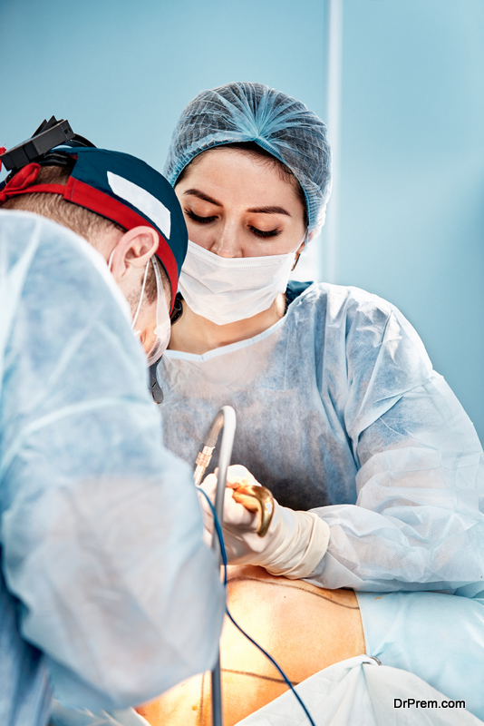 Surgeons operate on an anesthetized patient by suturing a wound surrounded by a second woman surgeons