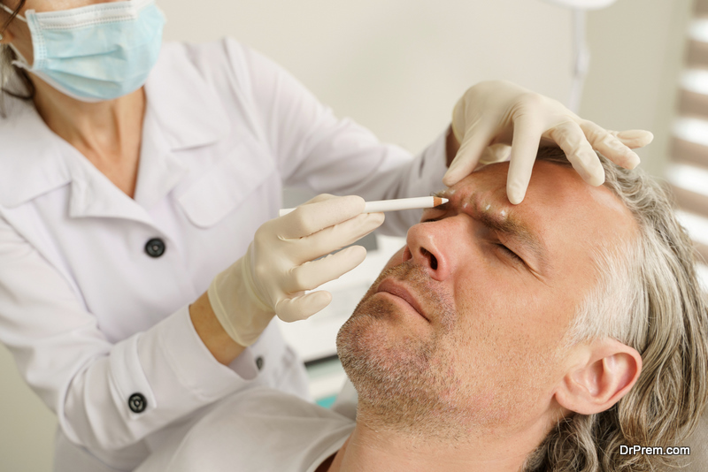 Female doctor making marks on client's face before filler injection