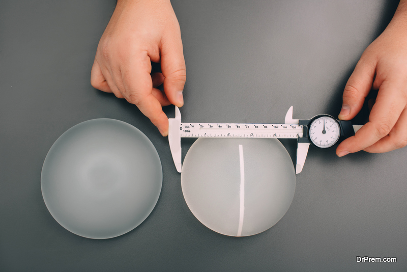 Surgeon measure size silicone breast implants, close-up, view from above. Cosmetic breast surgery