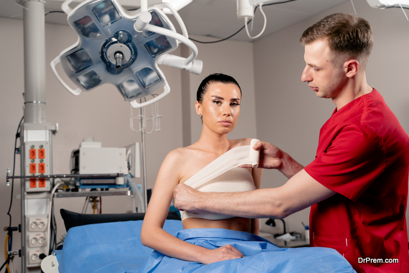 Surgeon with woman patient in operating room before breast augmentation for girl