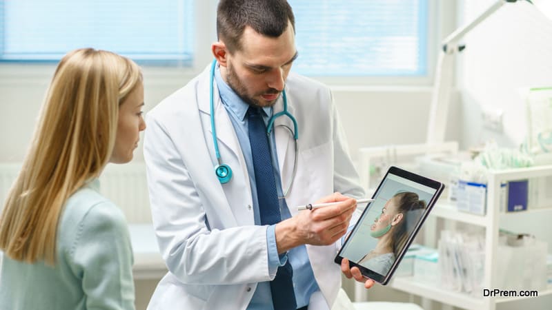 Plastic Cosmetic Surgeon Consults Woman about Facial Lift Surgery, He Draws Arrows on Digital Tablet Computer Screen, Showing Types of Facelift, Forehead Correcting Procedures Available for Her.