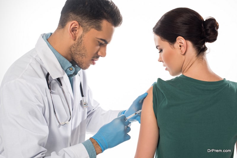 Handsome doctor doing vaccine injection to patient 