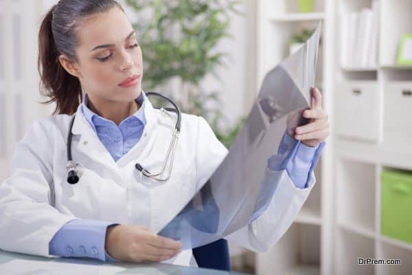 beautiful young woman orthopedist examine X-rays