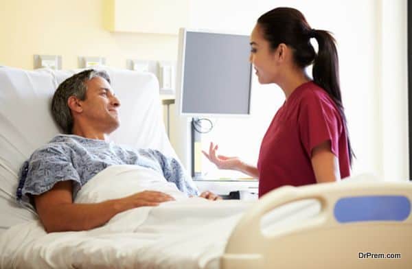 Nurse Talking To Male Patient In Hospital Room