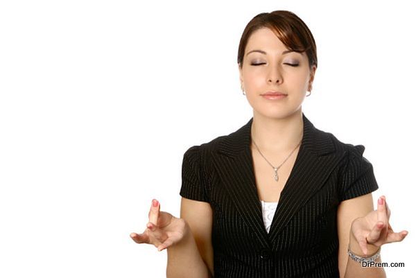 Businesswoman taking a break, concentrating on some yoga breathing exercise as part of a relaxation technique.