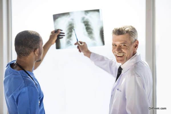 The doctors looking at an x-ray results in hospital. Doctors looking at camera.