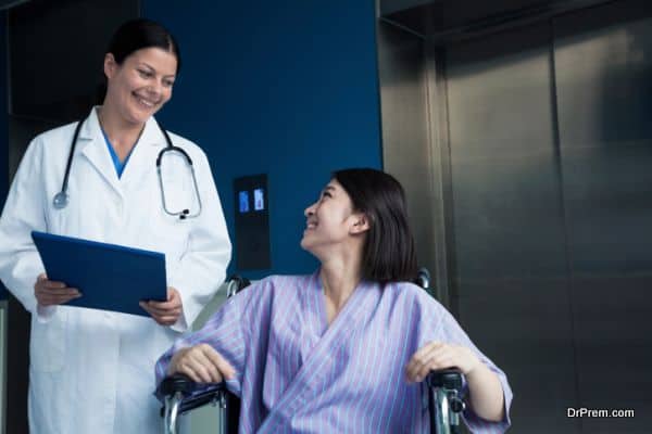 Patient sitting in a wheelchair, looking at doctor beside her