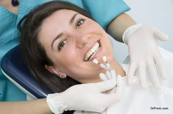 A dentist showing porcelain teeth to pacient