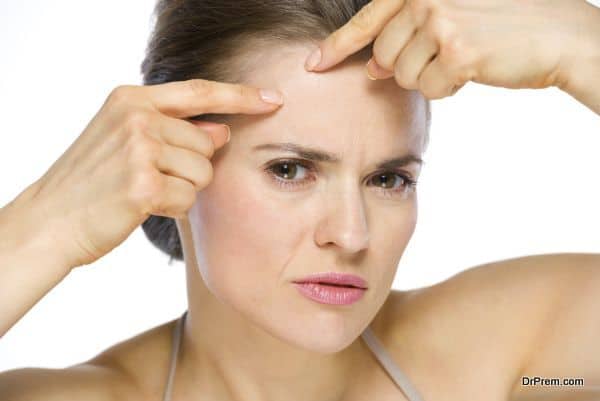 Beauty portrait of young woman squeezing acne