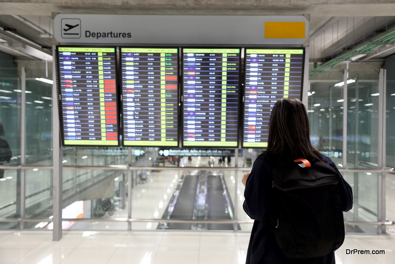  woman standing in front of flight information board