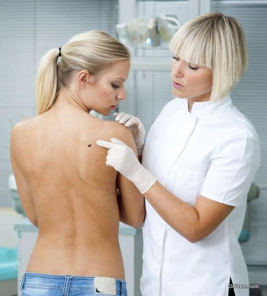 dermatologist doctor inspecting woman patients skin on her back for melanoma