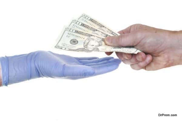 Patient Giving Doctor Money Representing Rising Healthcare Costs