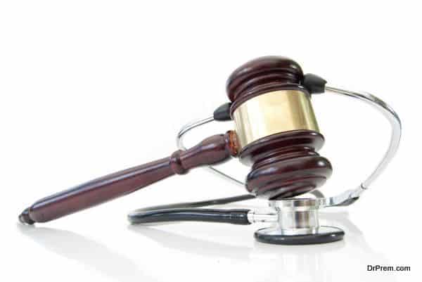 Stethoscope wrapped around a gavel over a white background