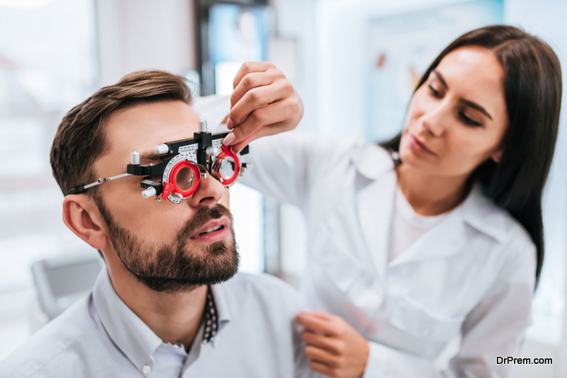  female doctor ophthalmologist is checking the eye vision of handsome young man 