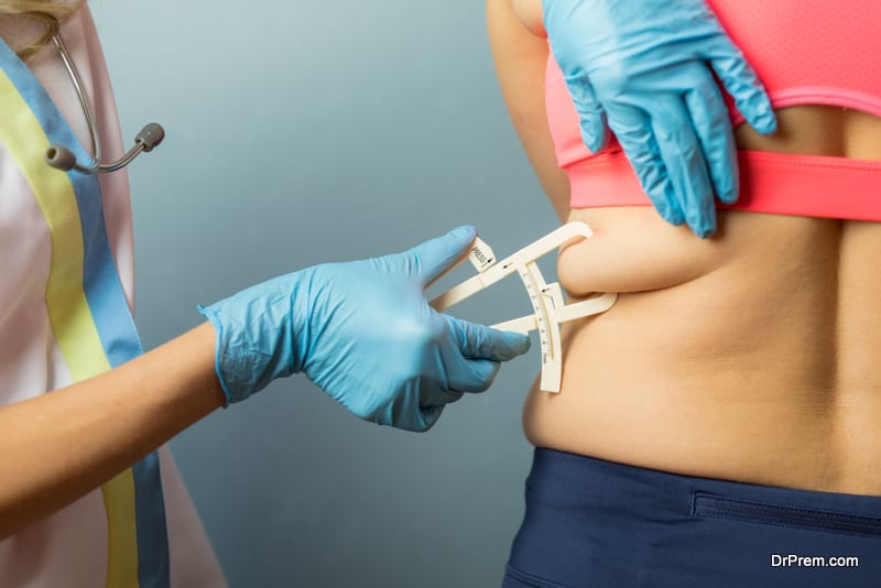 Doctor using body fat caliper 
