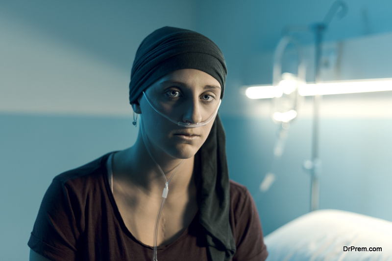 Young sad woman with cancer sitting on the hospital bed, she is looking at camera, illness and healthcare concept