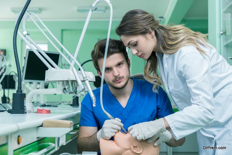 Dental prosthesis, dentures, prosthetics work. Prosthetics hands while working on the denture, false teeth, a study and a table with dental tools