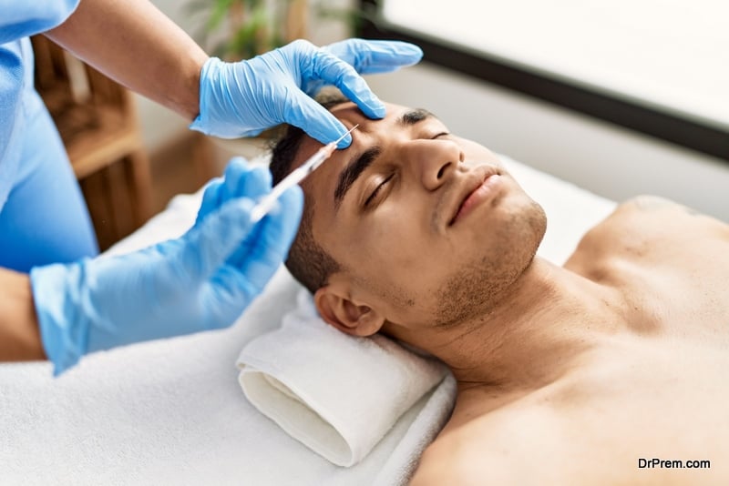 Doctor injecting botox on man face for anti aging treatment at the clinic.