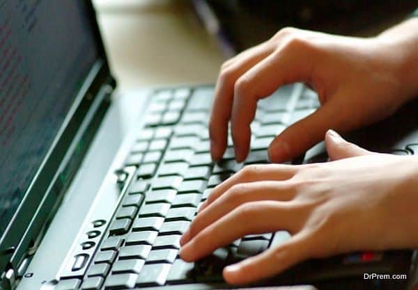 Hands typing on laptop keyboard.