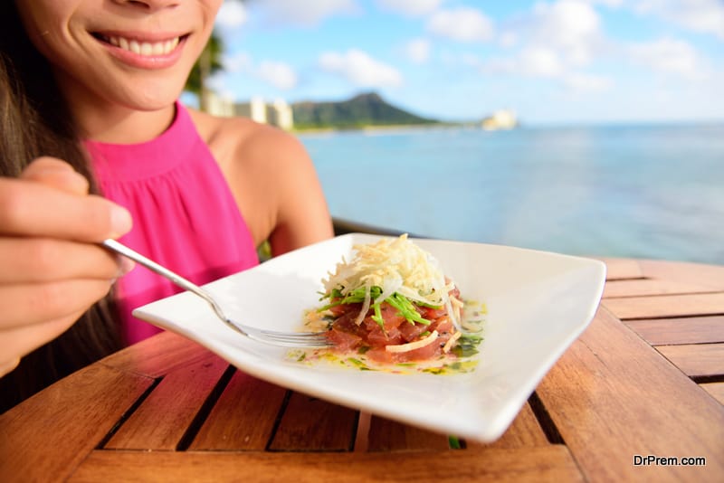 Tuna tartare. Raw ahi, Hawaiian food. Woman eating dish on Waikiki, Oahu, Hawaii.