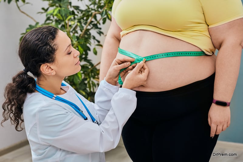 inspecting a woman's waist using a measuring tape 