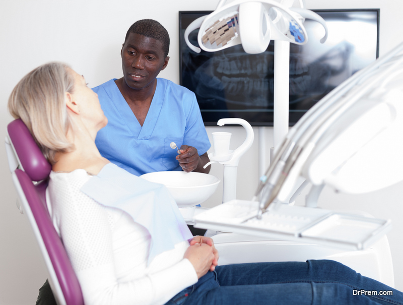 Professional positive doctor man talking with patient in medical chair