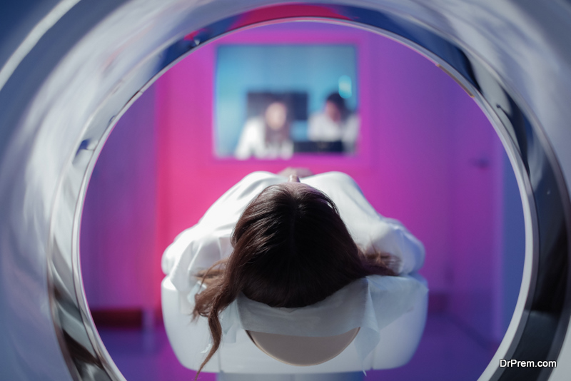 The girl patient is lying in the tomograph and waiting for a scan