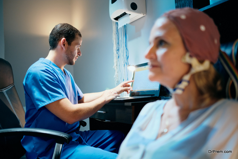 Doctor performing EEG exam to old woman in hospital laboratory