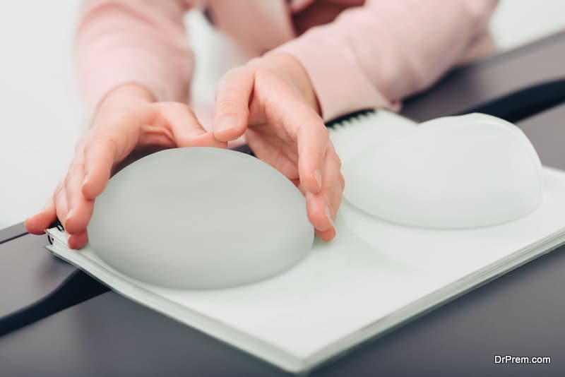 breast augmentation. woman chooses breast implant, close-up silicone breast implant