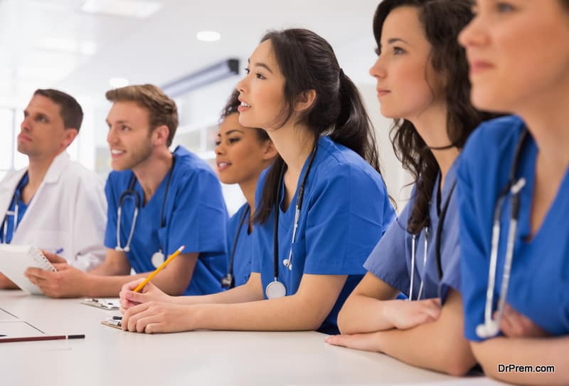 Medical students listening sitting at desk