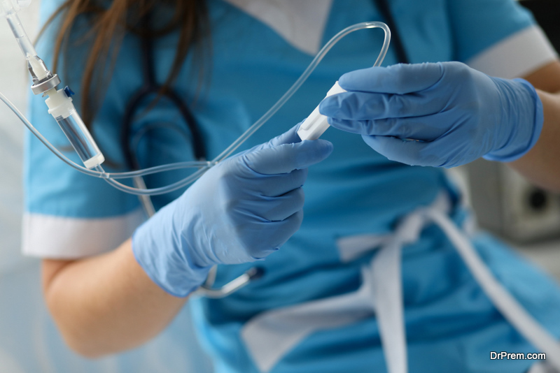  Female-nurse-hand-in-blue-protective-gloves-hold-dropper-against-medicine