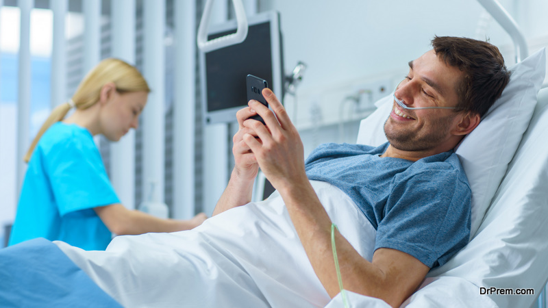 Recovering Patient Uses Smartphone while Lying on a Bed in the Hospital