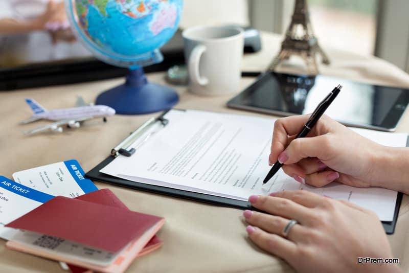 A female travel agent in the office signs a contract, close-up.