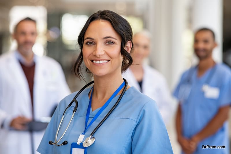 Beautiful and satisfied healthcare worker standing in private clinic and looking at camera