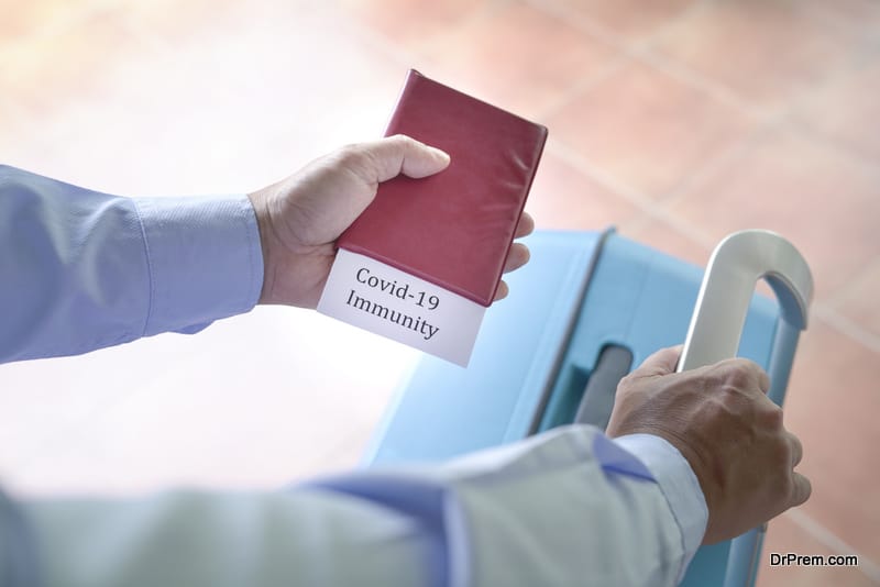 Traveler holding a passport with Covid-19 Immunity label inside. Travel concept during Covid-19 pandemic.