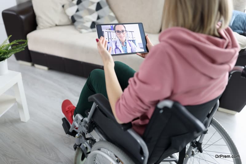 Woman in wheelchair holding tablet with picture closeup. Online medical consultations concept