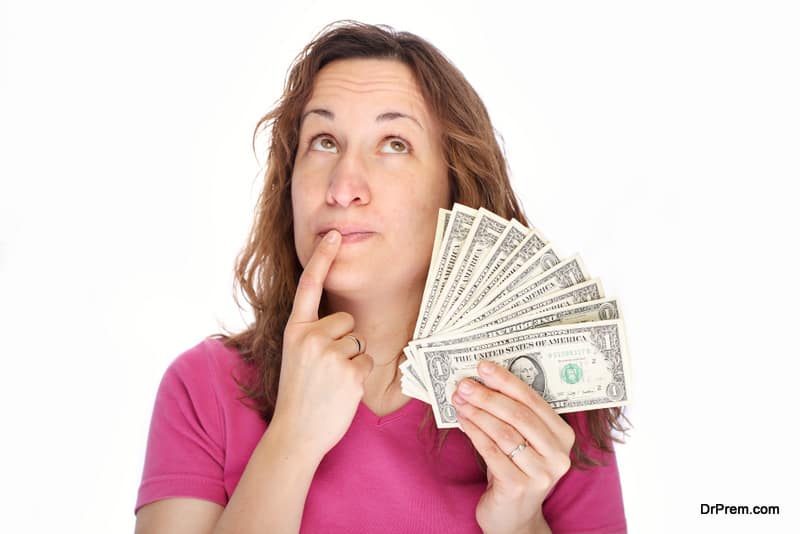 Young thoughtfully woman with money in hand