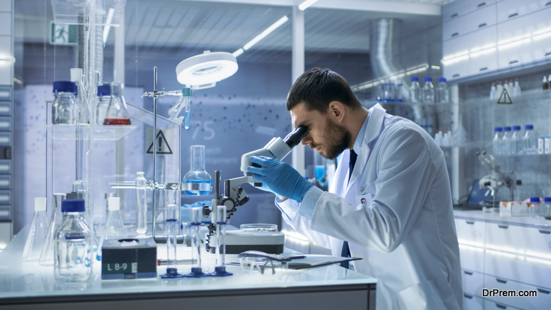 Research Scientist Looks into Microscope. He's Conducts Experiments in Modern Laboratory