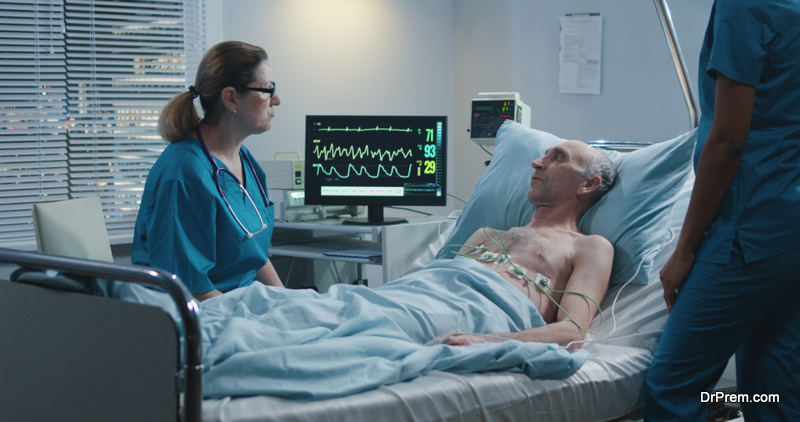 female doctor talking with an elderly male patient after putting ECG cables