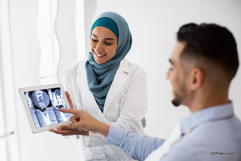Islamic Dentist Doctor Woman Showing Teeth Xray Shot On Digital Tablet