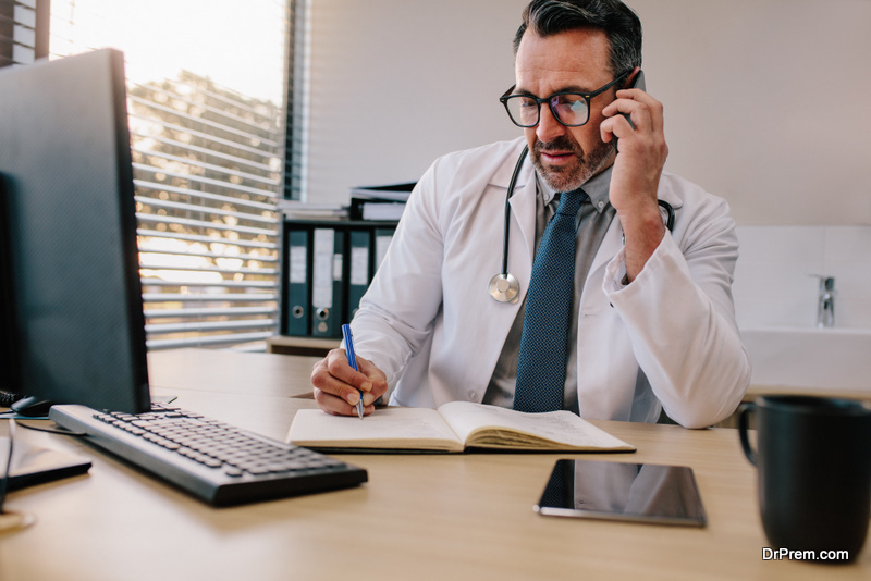 Doctor talking on phone and making notes 