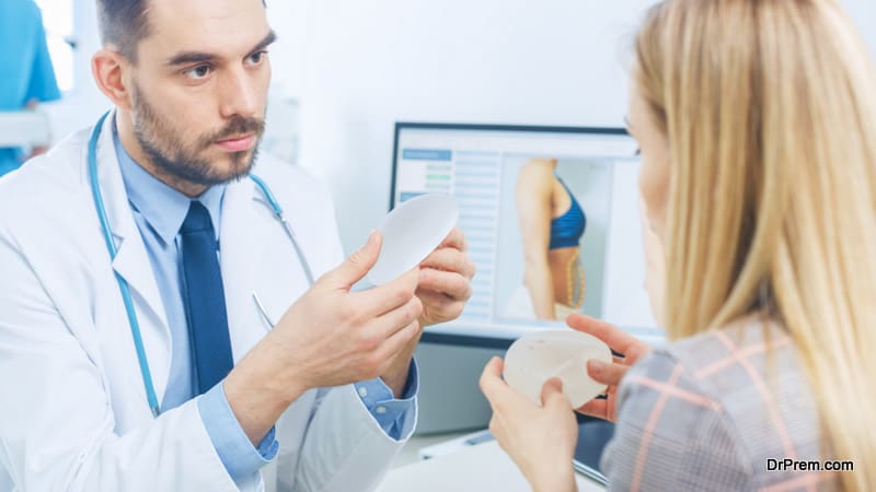 Plastic Cosmetic Surgeon Shows Female Patient Breast Implant Samples for Her Future Surgery. Professional and Famous Surgeon Working in Respectable Clinic.