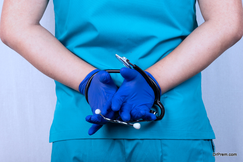 A doctor in blue uniform with a stethoscope tied in his hands. The concept of obligations, restrictions, contracts, crimes.