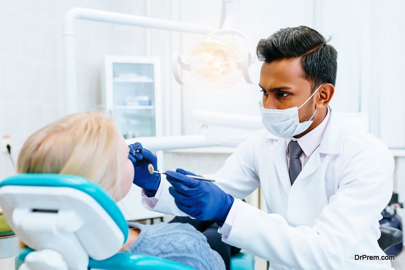 indian Male dentist Medical treatment to a female patient at the clinic