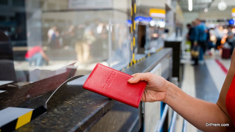 woman giving her passport at the airport check-in counter