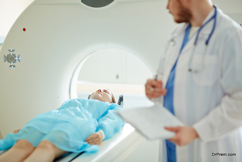 Doctor examining female patient with CT scanner