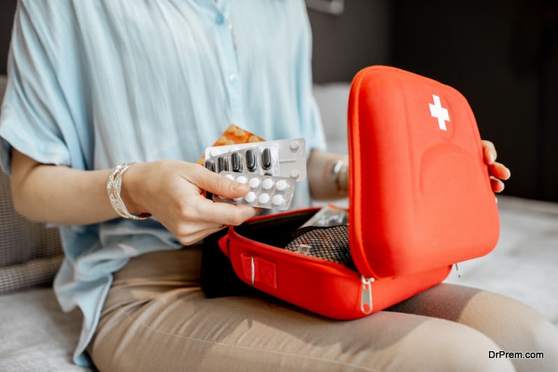 Woman taking pills from the first aid kit, close-up with no face