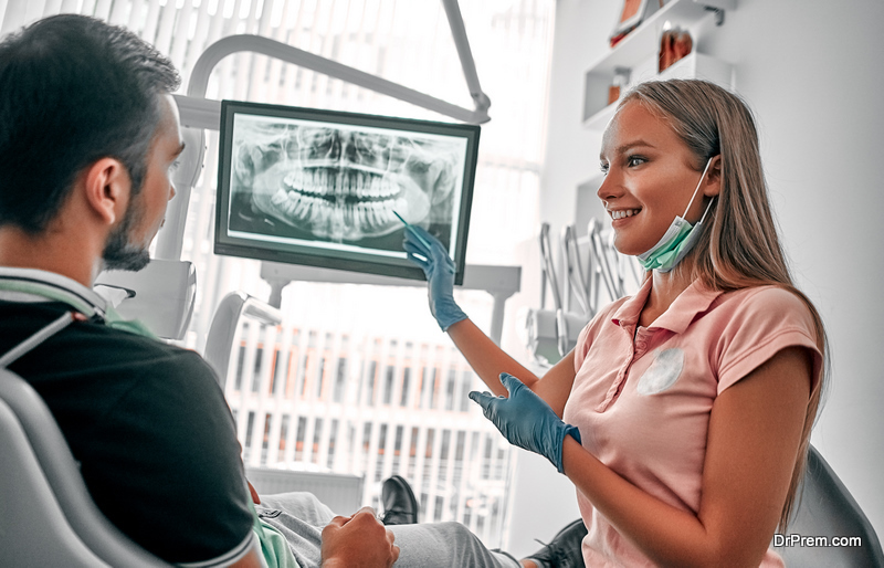  dentist presenting with tooth x-ray film recommend patient in the treatment of dental and dentistry