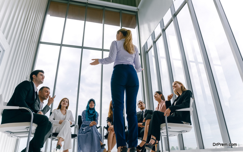 Businesswoman speaker giving a talk at business meeting. Audience in conference room.